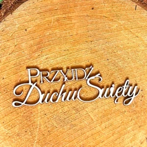 Scrapka z napisem „Przyjdź Duchu Święty” z białej tektury, leżąca na tle drewnianego plastra.